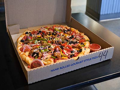 A pizza from Blind Onion in Vancouver. The pizza is sitting on a table in a cardboard box with the lid open.